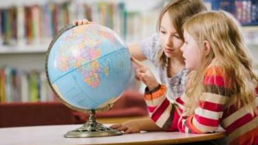 Elementary children looking at a globe